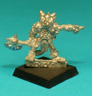 Pose 4, variant B. This figure appears to be a Kobold leader, armed with a handaxe in his right hand, and pointing with his left. He is looking forwards and has 2 long, pointed horns and small ears, with a warty complexion and a closed mouth.