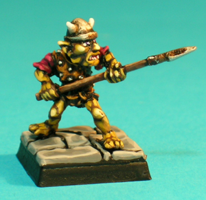 Pose 2, variant A. This figure wears a sleeveless leather shirt with iron studs sewn onto it, and is thrusting forwards with a spear. He appears to be stepping tentatively forward, with his left foot leading. This variant wears a horned conical steel helmet with a raised rim, and he is looking along the length of his spear. His partly open mouth has upper fangs barely visible.