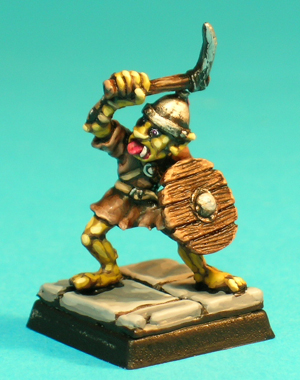 Pose 4, variant A. This figure wears a ragged tunic with leather crossbelts, and he wields a short, single-bladed pick high in his right hand. He appears to be about to attack with his bodyweight leaning to his right. This variant wears a conical steel helmet with a raised, rivetted rim and a thin horse-hair plume, and he is looking to his right. His mouth is open with a broad tongue protruding.