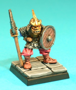 Pose 2, variant A. This pose is a Hobgoblin wearing scale armour with a plain breastplate. He has a dagger in a plain sheath, and a small sack attached to the rear of his belt. This variant is armed with a polearm with a narrow curved, single-bladed head, with the blade facing forwards. He wears a round helmet with an anchor-shaped symbol on the front, and a scalemail neckguard. His head looks forwards, with a slightly open, snarling mouth.
