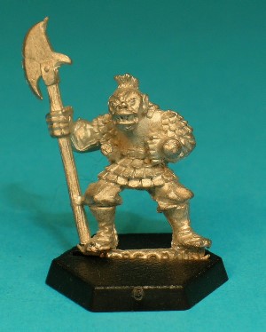 Pose 2, variant F. This variant is armed with a polearm with a wide axe blade on one side and a smaller, down-turned rear spike. The blade is facing to the right. He is bare-headed, with a mohican-style haircut on top and long-staggly hair at the back. His head looks forwards, with a partly-open mouth and a slightly protruding teeth.