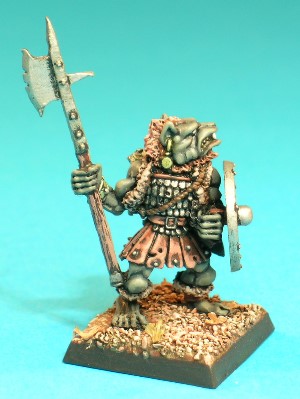 Pose 3, variant A. This Gnoll wears a skirt made of studded leather strips, a tunic of small overlapping steel plates, and a ratty old fur waistcoat. He carries a scabbarded broadsword strapped to his back, he protects himself with a shield on his left arm and holds an upright pole-weapon in his right hand. This variant is bare-headed, revealing a short mohican-style haircut. His polearm is a halberd, with a broad, notched axe-blade on the far side (in relation to the Gnoll) and a short spike on the nearside. The Gnoll has a dog-like face with a short muzzle, and a snarling mouth revealing upper fangs and a set of teeth. His head is tilted slightly back and he looks over his left shoulder. He has an earring with a hanging disc (a dog-tag?) in his right ear and 2 plain rings in his left. Pose 3, variant A. This Gnoll wears a skirt made of studded leather strips, a tunic of small overlapping steel plates, and a ratty old fur waistcoat. He carries a scabbarded broadsword strapped to his back, he protects himself with a shield on his left arm and holds an upright pole-weapon in his right hand. This variant is bare-headed, revealing a short mohican-style haircut. His polearm is a halberd, with a broad, notched axe-blade on the far side (in relation to the Gnoll) and a short spike on the nearside. The Gnoll has a dog-like face with a short muzzle, and a snarling mouth revealing upper fangs and a set of teeth. His head is tilted slightly back and he looks over his left shoulder. He has an earring with a hanging disc (a dog-tag?) in his right ear and 2 plain rings in his left.