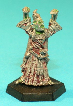 Pose 1, variant E. This variant has a flesh-covered face, and wears a battered wizard's hat without a brim. He has long, straggly hair, his mouth is open as if snarling and he looks to his left. Pose 1, variant E. This variant has a flesh-covered face, and wears a battered wizard's hat without a brim. He has long, straggly hair, his mouth is open as if snarling and he looks to his left.